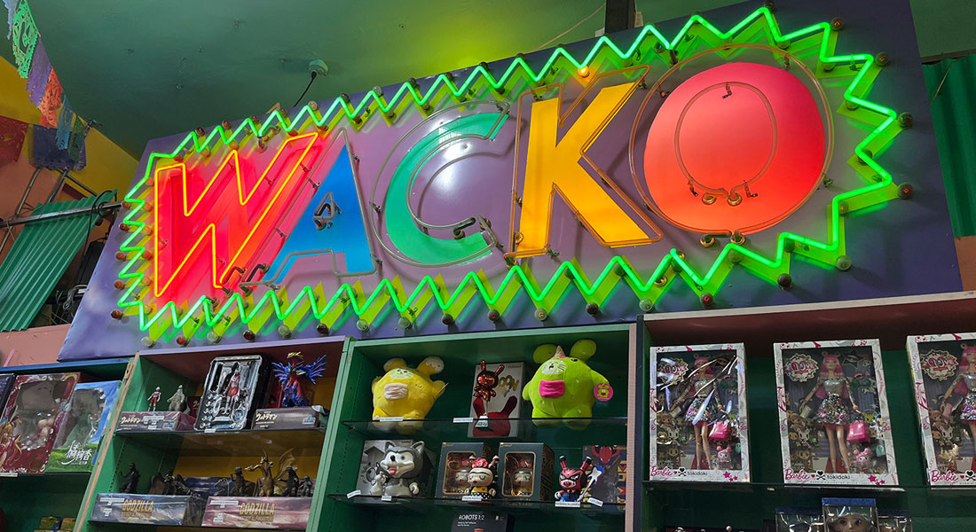 Wacko neon sign inside store above toys